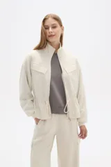 Campera de cuello alto con cierre frontal, bolsillos frontales con solapa y cordón ajustable en la cintura. Diseño de manga larga con puños elásticos.