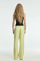 Pantalón de tiro medio confeccionado en mezcla de lino, con cintura ajustable mediante lazada, trabillas, bolsillos laterales y cierre frontal con cremallera y botón.