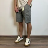 Bermuda cargo color gris de gabardina, con bolsillos laterales y traseros con solapa.