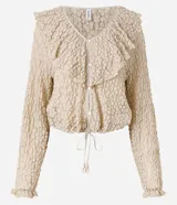 Blusa tipo bata de encaje texturizado color beige, con escote en V, mangas largas y volados aplicados en el escote. Presenta cierre frontal con botones y lazo de ajuste en la cintura.