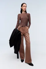 Remera plateada de lurex con escote redondo, calce al cuerpo y mangas largas estilo princesa.