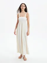 Monoprenda larga color blanco off white, con escote cuadrado y cuerpo estilo nido de abeja elástico. Presenta tirantes anchos y perneras amplias y sueltas.