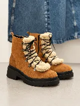 Bota tipo borcego de cuero color suela, con aplique de corderito sintético desmontable en la lengüeta, cordones negros y suela track de goma negra.