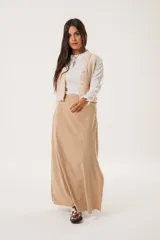 Falda larga color beige confeccionada en tela suave con acabado tipo piel de durazno y cierre invisible lateral.