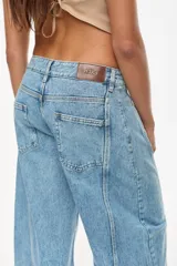 Jean de denim celeste de tiro alto y silueta wide leg, con costuras marcadas, bolsillos funcionales, bolsillo trasero inferior con bordado y terminación desflecada en el ruedo.