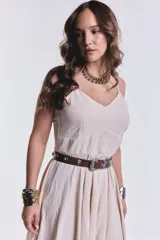 Vestido midi color beige de breteles finos, corte asimétrico y falda con volados.