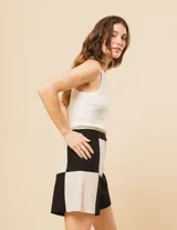 Short de lino color beige y naranja, de tiro alto con elástico en la pretina trasera, cierre delantero y botón, bolsillos delanteros y dobladillo invisible.