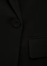 Blazer de corte recto y diseño clásico, con solapas con muesca, cierre frontal de un botón, bolsillos laterales con solapa y bolsillo de ribete en el pecho. Cuenta con forro interior y mangas largas.