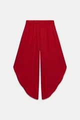 Pantalón fluido de tiro alto en color blanco, con pinzas delanteras, cintura elástica en la espalda y perneras anchas con aberturas laterales pronunciadas.