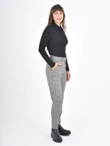 Pantalon de vestir de corte recto y tiro medio, con estampado de cuadros en tonos grises. Cuenta con bolsillos laterales y cierre frontal con botón y cremallera.