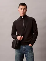 Cartera reporter Calvin Klein color negro, con diseño acolchado y pespuntes que forman el monograma de la marca. Cuenta con compartimento principal con cierre, bolsillo delantero con cremallera y correa ajustable para el hombro.
