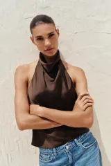 Top de cuello halter satinado en color naranja tostado, con espalda descubierta y cierre trasero de botones.