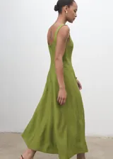 Vestido midi de corte evasé en color verde oliva, con escote cuadrado, tirantes anchos y costuras decorativas verticales que estilizan la silueta. Cuenta con cierre de cremallera en la parte posterior y forro interior.