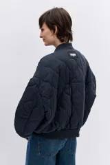 Cazadora tipo bomber de color negro con diseño acolchado de rombos, cuello, puños y ruedo acanalados, cierre frontal y bolsillos laterales.