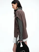 Chaleco de tejido de punto con lana y alpaca, de corte relajado y caída recta. Presenta laterales abiertos con cierre de botones y cuello redondo.