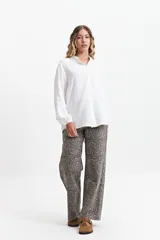 Camisa de manga larga color blanco, con cuello mao y corte holgado. Confeccionada en tejido tipo lino.