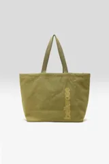 Bolso tote reversible color verde militar confeccionado en lona, con doble asa superior y logo estampado vertical en el frente.