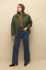 Campera capitoneada negra con botones veteados, bolsillos laterales de solapa y forro de satén con estampado animal print.