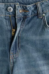 Jean wide leg de denim azul con lavado medio, tiro regular, diseño de cinco bolsillos y perneras amplias y rectas.
