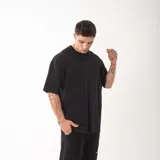 Remera de algodón premium con corte oversize y diseño unisex. Presenta bordado frontal con la palabra GAINS y bordado en la espalda con la palabra RESILIENCE.