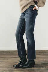 Jeans de tiro alto color marrón oscuro con acabado lavado, corte recto/flare y bajo cropped sin costuras. Presenta cinco bolsillos y cierre frontal con cremallera y botón metálico.