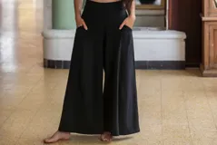 Pantalón palazzo negro de algodón, corte evasé, tiro alto, con bolsillos laterales, elástico en la espalda y faja ancha.