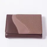 Billetera de diseño compacto en tonos marrones y bordó, combinando secciones de cuerina lisa y una parte frontal con textura geométrica.