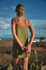 Vestido corto verde oliva de lino y rayón, con escote recto y breteles regulables.