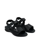 Sandalia plana color negro con tiras ajustables con velcro, confeccionada en cuero con detalles texturizados.