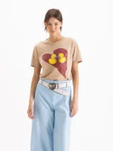 Remera gris oscuro con efecto acid wash, corte clásico, mangas cortas y cuello redondo. Cuenta con una estampa frontal de un corazón rojo con dos patitos amarillos besándose.