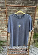 Remera de algodón premium color negro con efecto lavado, de manga corta y corte holgado. Presenta un estampado gráfico en la espalda con el texto 'Good Trips, Good Friends' y una ilustración de personajes apilados.