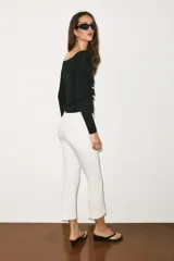 Pantalón mini flare de tiro medio, color negro, con diseño evasé y raya central marcada. Cuenta con cierre lateral mediante cremallera oculta.