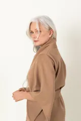 Chaquetón negro italiano con mangas irregulares, lazo y flecos en el ruedo.