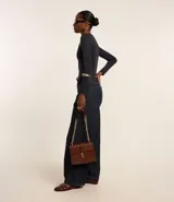 Body de manga larga con escote bote, confeccionado en tejido de media malla suave y elástico. Presenta un diseño ajustado al cuerpo con cierre en el entrepiernas.