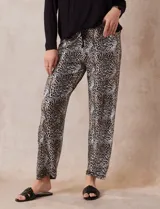 Conjunto de pijama marca René Rofé, compuesto por remera negra de manga larga con bolsillo en el pecho y pantalón largo con estampado animal print, cintura elastizada y lazo de ajuste.