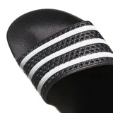 Ojotas Adidas modelo Adilette, color negro con las tres bandas características de la marca en color blanco sobre la banda superior. Diseño ergonómico con suela moldeada para mayor comodidad.