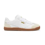 Championes Puma modelo Club 5V5, de diseño urbano inspirado en el fútbol sala. Presenta una base de cuero sintético blanco con refuerzos de gamuza en la puntera y el talón en tono beige, y una suela de goma color caramelo. Incluye el logo de la marca en dorado en el lateral y la lengüeta.