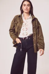 Sobrecamisa de gamuza sintética en color marrón chocolate, con corte oversize, cuello camisero, cierre frontal con botones y bolsillos frontales tipo parche.