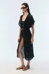 Kimono largo de algodón negro con punto calado, calce amplio, hombros caídos, mangas cortas, aberturas laterales y terminación desflecada en el ruedo.