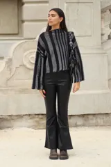 Sweater tejido de punto a rayas horizontales negras y plateadas, con cuello alto, mangas tres cuartos y calce oversize.