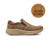 Zapato casual tipo slip-on de cuero color marrón, con diseño ergonómico y suela de goma texturizada en tono beige.