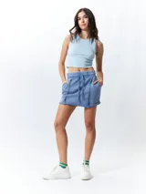 Minifalda color beige con elástico en la cintura, cordones ajustables y costuras marcadas en los laterales.