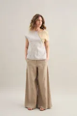 Pantalon largo de lino color tostado, tiro alto, corte ancho y recto, con costuras centrales decorativas y bolsillos laterales.