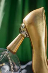 Zapato de tacón plateado, con punta fina y taco con forma de esfera.