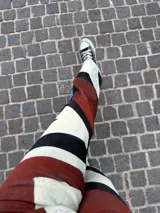 Pantalón de jean de tiro alto con diseño de rayas horizontales en color bordó, blanco y negro.