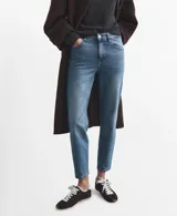 Pantalón de jean de corte recto y tiro medio, con diseño clásico de cinco bolsillos y cierre frontal con botón y cremallera. Presenta un acabado en tono azul medio con sutiles desgastes.
