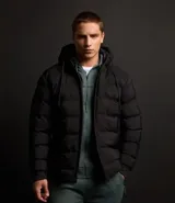Campera puffer deportiva Get Over, color negro, con capucha, cierre frontal por cremallera y puños elásticos. Diseño acolchado sin costuras visibles.