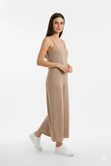 Mono de lino color beige con breteles finos, escote en V y diseño holgado de pierna ancha.