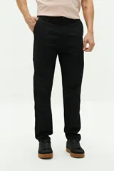 Pantalón chino de corte regular, color negro, con cierre frontal de botón y cremallera, bolsillos laterales y pasacintos en la cintura.
