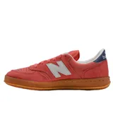 Championes New Balance modelo 500, color rosado con detalles en blanco y suela de goma color caramelo. Presenta el logo característico en los laterales y refuerzo en el talón en color azul marino.